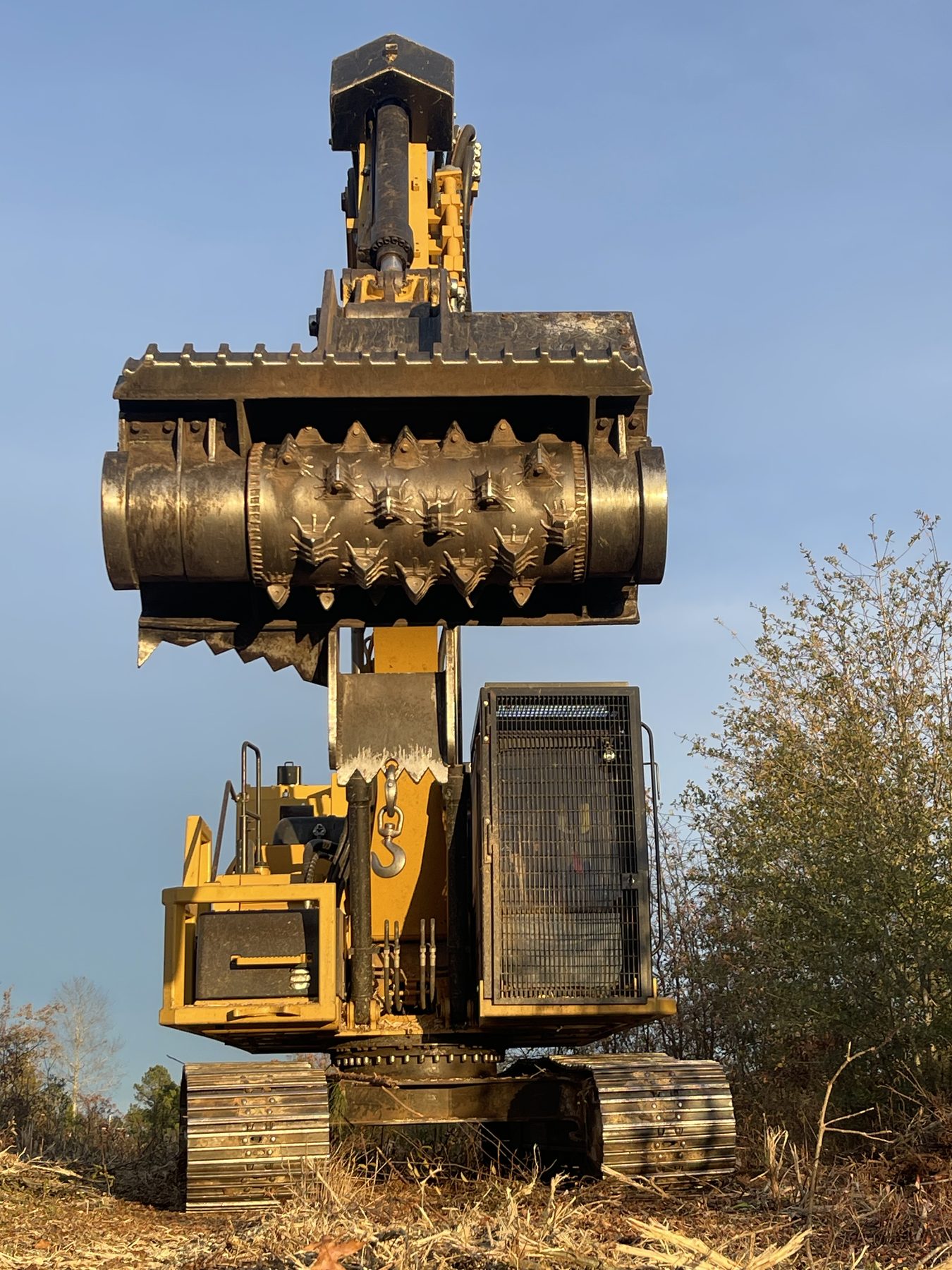 Excavator with mulcher attachment on freshly cleared land